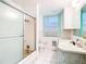 Bright bathroom featuring a tub with shower, white tile, and a window for natural light at 649 Ave J Nw, Winter Haven, FL 33881