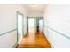 Long hallway featuring fresh paint and hardwood floors, connecting multiple rooms in the home at 649 Ave J Nw, Winter Haven, FL 33881