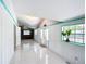 Bright sun room with tile floors, white wood paneling, teal trim, multiple windows and a garden view at 649 Ave J Nw, Winter Haven, FL 33881