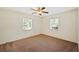 Bright, airy bedroom with neutral carpet, a ceiling fan, and two large windows at 6529 Farris Dr, Lakeland, FL 33811