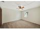 Spacious bedroom with a ceiling fan, neutral carpet, and a large window at 6529 Farris Dr, Lakeland, FL 33811