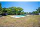 Backyard pool surrounded by a green lawn and mature trees at 6529 Farris Dr, Lakeland, FL 33811