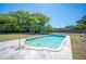 Backyard swimming pool surrounded by a spacious lawn and mature trees at 6529 Farris Dr, Lakeland, FL 33811