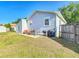 Back of house with fenced yard, patio seating and grill, with green lawn at 737 Kensington St, Lakeland, FL 33803