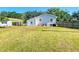 View of backyard with fenced yard, patio seating and grill, with green lawn at 737 Kensington St, Lakeland, FL 33803