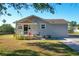 Charming single-story home with gray siding, a covered front porch, and well-maintained landscaping at 737 Kensington St, Lakeland, FL 33803