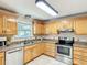 Well-lit kitchen featuring wood cabinets, granite countertops, and stainless steel appliances at 737 Kensington St, Lakeland, FL 33803