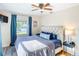 Comfortable main bedroom with blue accents and natural light from the window at 737 Kensington St, Lakeland, FL 33803