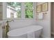 Elegant bathroom showcases a soaking tub, natural light and modern fixtures at 746 Mississippi Ave, Lakeland, FL 33801
