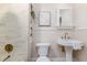 Bright bathroom with marble tile shower, modern fixtures, and stylish pedestal sink at 746 Mississippi Ave, Lakeland, FL 33801