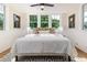 Comfortable bedroom with three large windows, hardwood floors, and a ceiling fan at 746 Mississippi Ave, Lakeland, FL 33801
