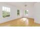 This bright bedroom features hardwood floors, three windows, and neutral paint at 746 Mississippi Ave, Lakeland, FL 33801
