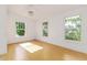 This bright bedroom features hardwood floors, three windows, and neutral paint at 746 Mississippi Ave, Lakeland, FL 33801