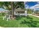 Beautifully landscaped front yard with a park bench and shade tree accenting this home at 746 Mississippi Ave, Lakeland, FL 33801
