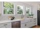 Bright kitchen featuring white cabinets, modern faucet, farm sink, and views of the landscape at 746 Mississippi Ave, Lakeland, FL 33801