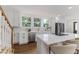 Bright kitchen features white cabinets, stainless steel appliances, a farmhouse sink, and a kitchen island with seating at 746 Mississippi Ave, Lakeland, FL 33801