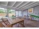 Screened-in porch features a wood table and chairs, brick flooring, and a view of the backyard at 746 Mississippi Ave, Lakeland, FL 33801