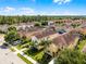 An aerial view shows a neighborhood with lush greenery, well-maintained lawns and colorful single Gathering homes at 8929 Sugar Palm Rd, Kissimmee, FL 34747