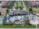 Aerial view of community clubhouse, pool, tennis courts, and playground amid lush landscaping and homes at 8929 Sugar Palm Rd, Kissimmee, FL 34747