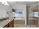 Bathroom with double sinks, soaking tub, tiled floors, and a glass-enclosed shower at 8929 Sugar Palm Rd, Kissimmee, FL 34747