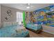 Bedroom featuring Toy Story themed wallpaper, ceiling fan, and two twin beds at 8929 Sugar Palm Rd, Kissimmee, FL 34747
