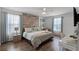 Stylish bedroom features a decorative wood accent wall, ceiling fan, and sleek furniture at 8929 Sugar Palm Rd, Kissimmee, FL 34747