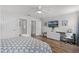 Bright bedroom with a ceiling fan, desk, dresser, and access to a bathroom at 8929 Sugar Palm Rd, Kissimmee, FL 34747