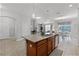 A kitchen island with bar stool seating overlooks the adjacent living and dining areas at 8929 Sugar Palm Rd, Kissimmee, FL 34747