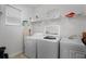 Efficient laundry room with a washer, dryer, utility sink, and storage shelves at 8929 Sugar Palm Rd, Kissimmee, FL 34747