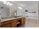 Bright main bathroom with granite countertops, dual sinks, a soaking tub, and a glass enclosed shower at 8929 Sugar Palm Rd, Kissimmee, FL 34747