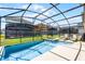 Beautiful pool and spa surrounded by a screened enclosure and lush green lawn at 8929 Sugar Palm Rd, Kissimmee, FL 34747