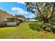 Expansive backyard with a screened porch and a view of horse stables in the distance at 930 Country Oaks Ln, Lakeland, FL 33810
