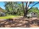 Large backyard with fire pit, bench, a shed, and mature trees at 930 Country Oaks Ln, Lakeland, FL 33810