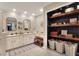 Bright bathroom featuring double sinks, framed mirrors, and a storage nook with shelves and baskets at 930 Country Oaks Ln, Lakeland, FL 33810