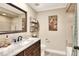Bathroom vanity with marble countertop, framed mirror, and decorative wall art at 930 Country Oaks Ln, Lakeland, FL 33810