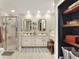 Bright bathroom featuring double sinks, framed mirrors, a shower, and a storage nook with shelves and baskets at 930 Country Oaks Ln, Lakeland, FL 33810
