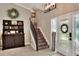 Inviting foyer with wood staircase, decorative shelving and a beautiful leaded glass front door at 930 Country Oaks Ln, Lakeland, FL 33810
