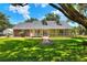 Charming ranch style home with a welcoming front porch and lush green lawn at 930 Country Oaks Ln, Lakeland, FL 33810