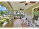 Charming screened porch with tile flooring, ceiling fan, and a swing and rocking chairs at 930 Country Oaks Ln, Lakeland, FL 33810