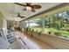 Inviting porch with tile flooring, ceiling fans, and a beautiful view of the backyard at 930 Country Oaks Ln, Lakeland, FL 33810