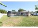 Backyard with a screened-in pool area and mature trees at 108 Sandburg Ln, Winter Haven, FL 33884