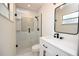 Bathroom with a glass enclosed shower with subway tile and a dark framed mirror over the vanity at 108 Sandburg Ln, Winter Haven, FL 33884