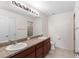 Bathroom featuring double sinks, brown cabinets and large mirror, and a separate shower stall at 11 W Bay St, Davenport, FL 33837