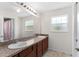 Bathroom featuring double sinks, light cabinets, and large mirror, and a separate shower stall at 11 W Bay St, Davenport, FL 33837