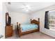 Charming bedroom featuring a bed, ceiling fan, and natural light from the window at 11 W Bay St, Davenport, FL 33837