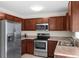 Well-equipped kitchen features stainless steel appliances and rich wood cabinetry at 11 W Bay St, Davenport, FL 33837