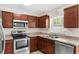 Modern kitchen featuring stainless steel appliances, wood cabinets, and a bright window at 11 W Bay St, Davenport, FL 33837