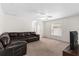 Open living room with neutral carpet, ceiling fan, and a leather sofa set at 11 W Bay St, Davenport, FL 33837
