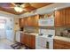 Bright kitchen boasts wood cabinets, a white microwave and oven, and a view of the laundry room at 1130 N Lake Parker Ave # C321, Lakeland, FL 33805