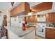 Cozy kitchen featuring wood cabinetry, a breakfast bar, and a full suite of appliances at 1130 N Lake Parker Ave # C321, Lakeland, FL 33805